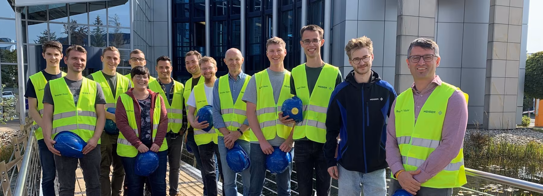 Group photo: People wearing safety helmets and high-visibility vests