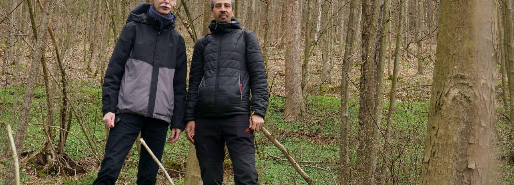 Zwei männliche Personen in einem Waldstück