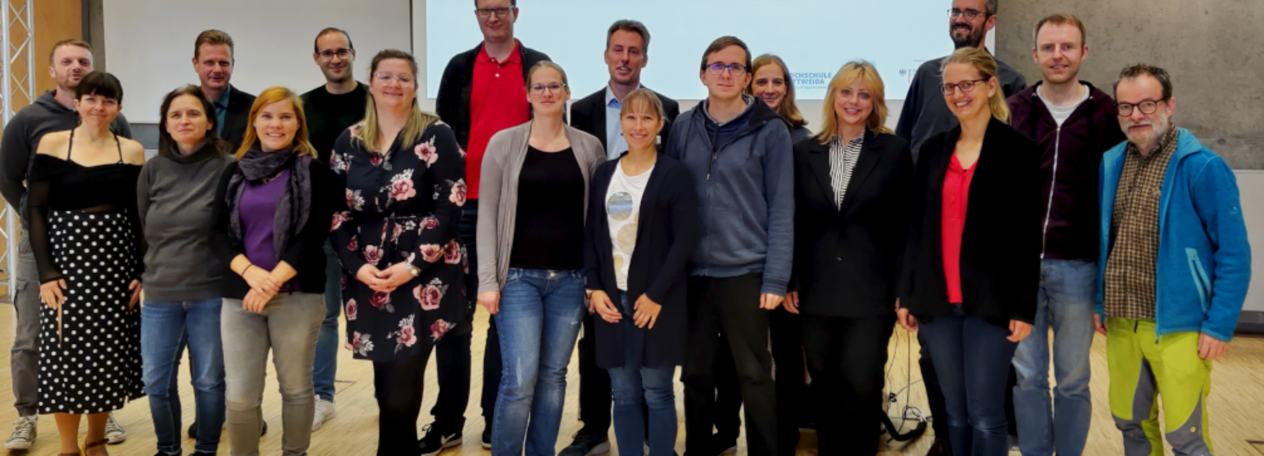 Gruppenbild von Personen vor einer Projektionswand