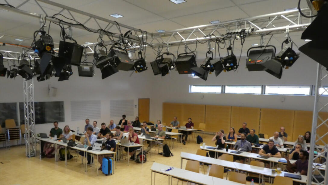 Blick in Unterrichtsraum, Personen sitzen an Tischen