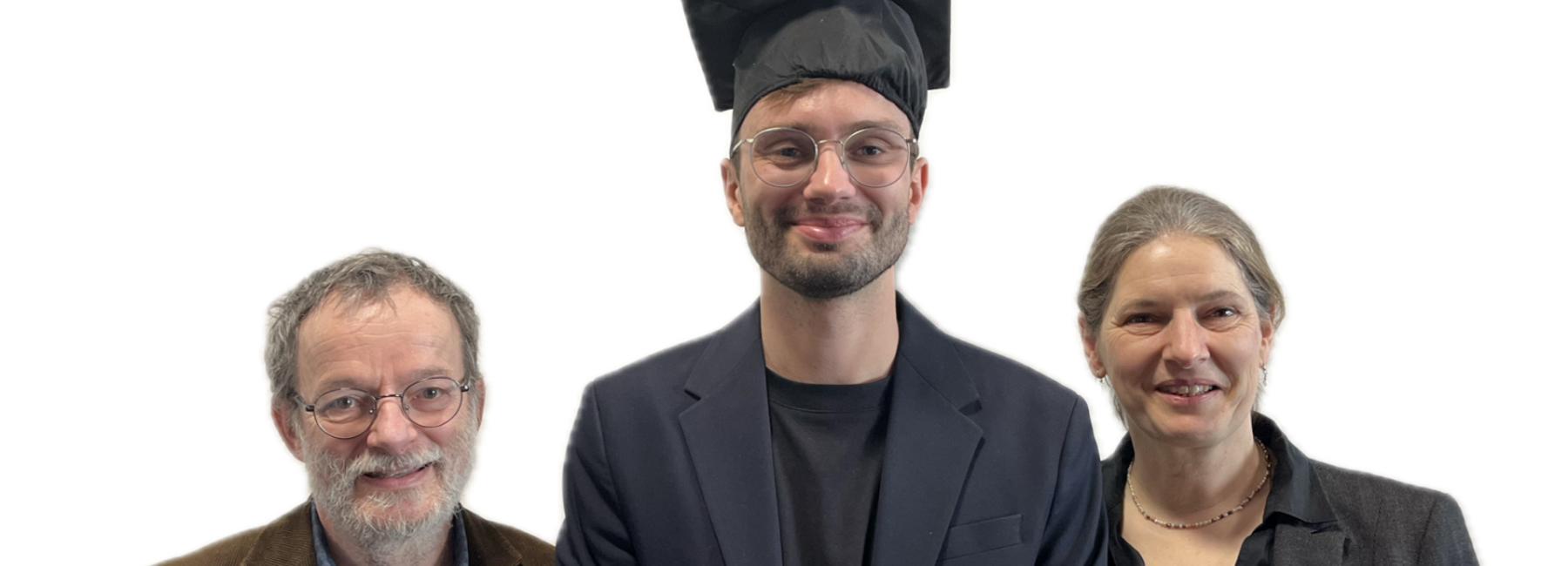 Zwei männliche und eine weibliche Person(en) stehen lächelnd vor einem weißen Hintergrund, die männliche Person in der Mitte trägt einen Doktorhut