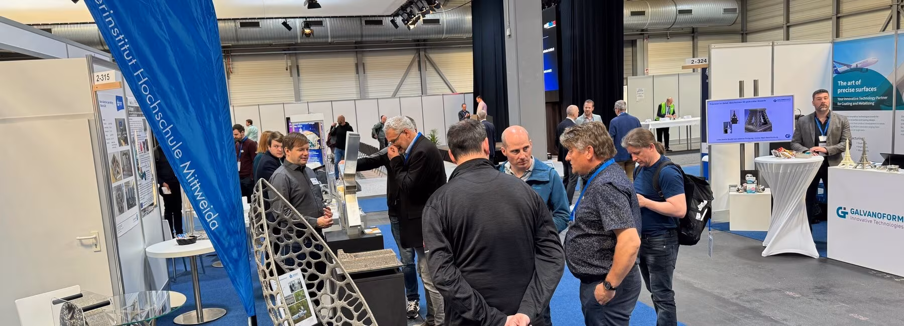 Blick auf einen Messestand mit Besuchenden