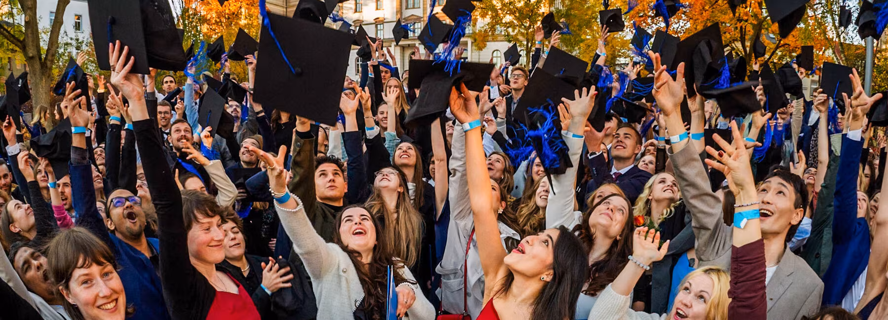Graduates joyfully throw their hats into the air