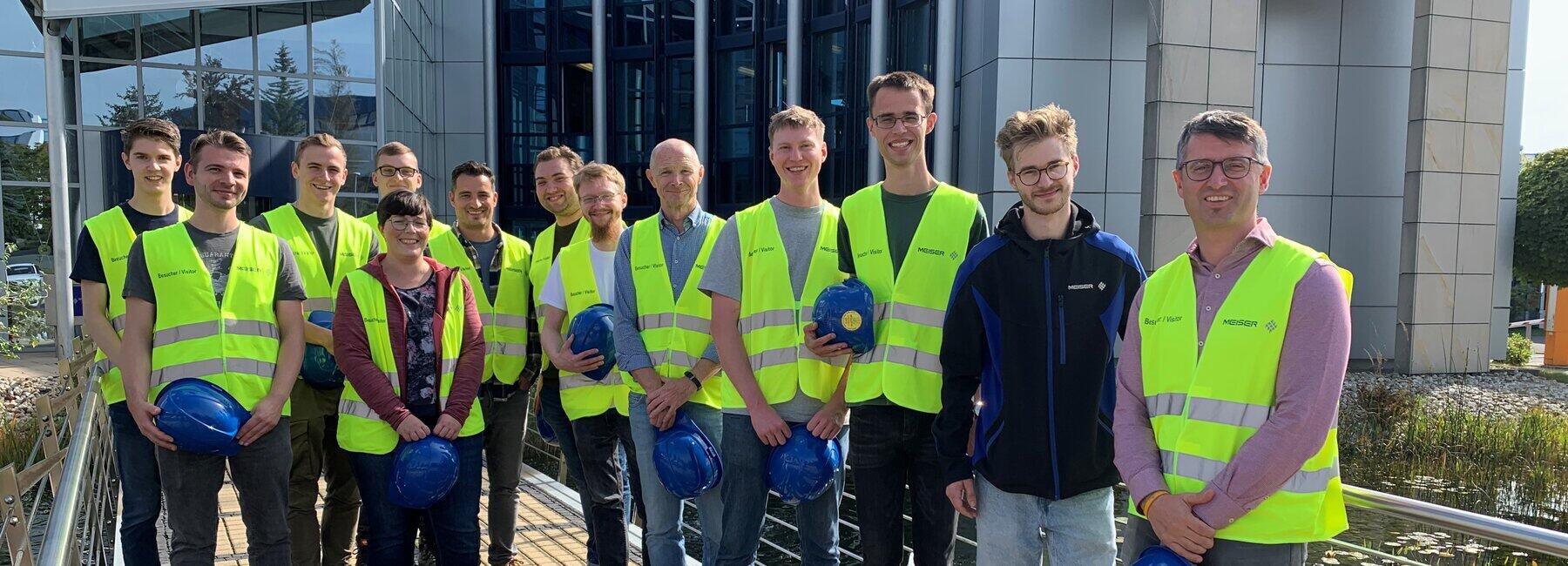 Gruppenbild: Personen mit Schutzhelm und Warnweste