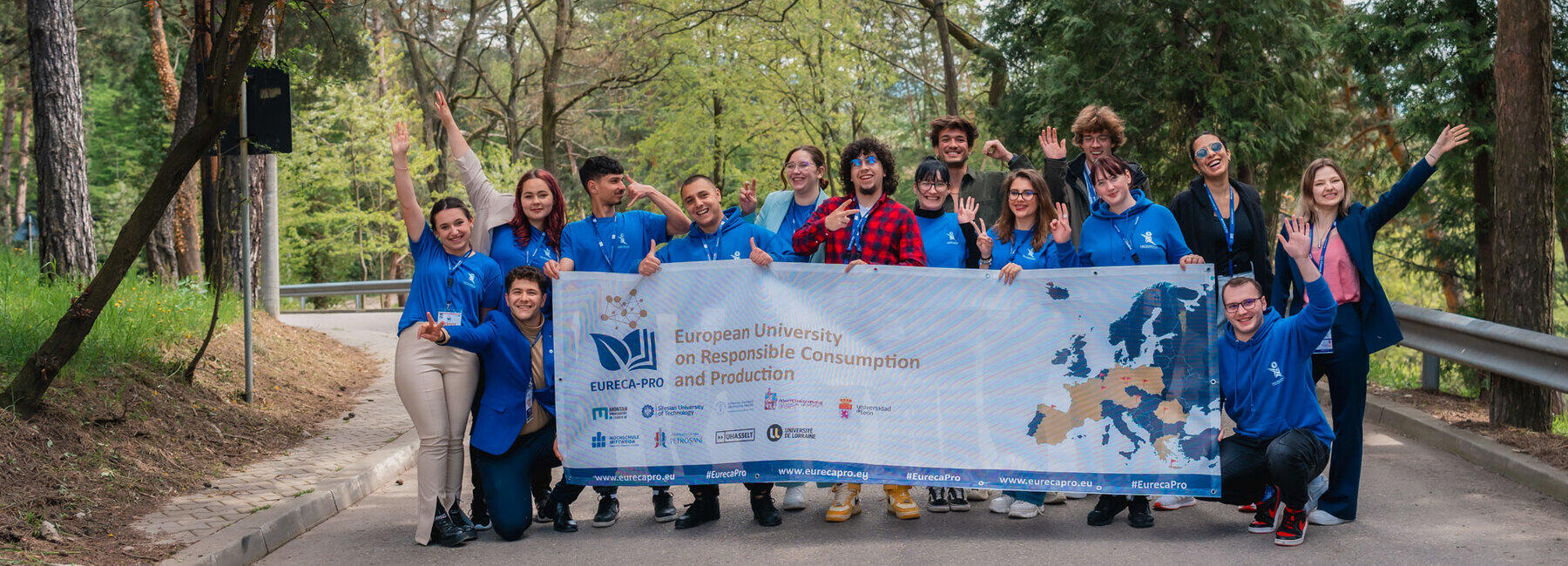 15 Studierende halten auf einem Gruppenbild einen großen Mesh-Banner mit einem Aufdruck der Hochschulallianz EURECA-PRO in die Kamera.