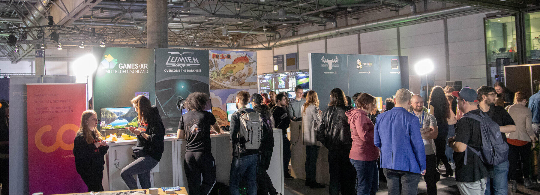 Blick auf einen Messestand, davor Menschengruppen