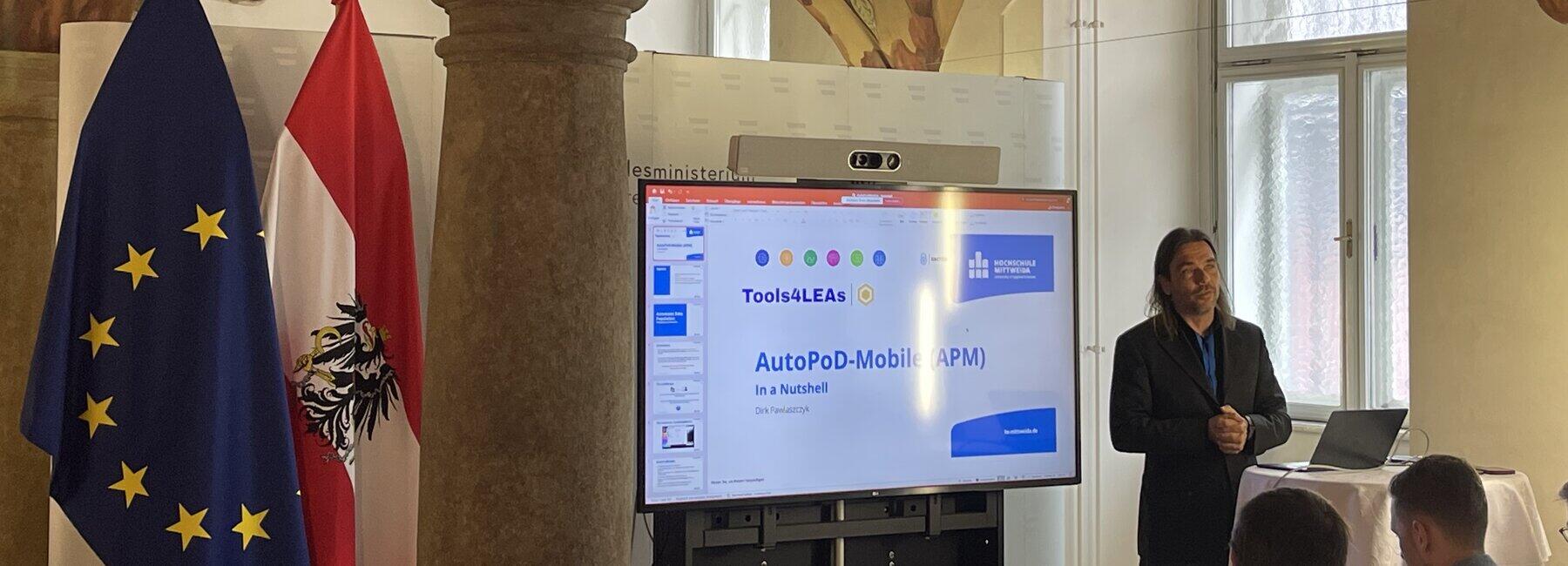 Männliche Person steht vor Präsentationsbildschirm