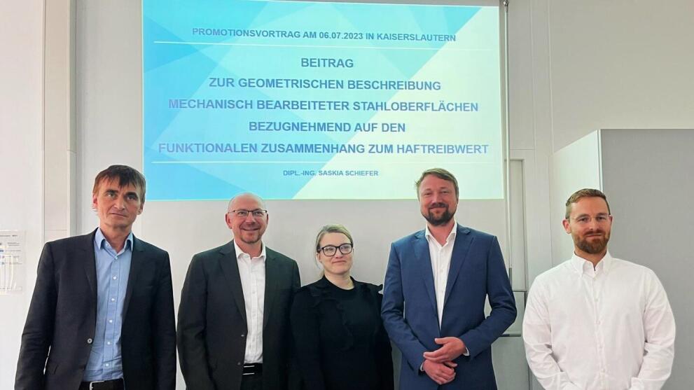 Fünf Personen stehen vor einer Projetionswand