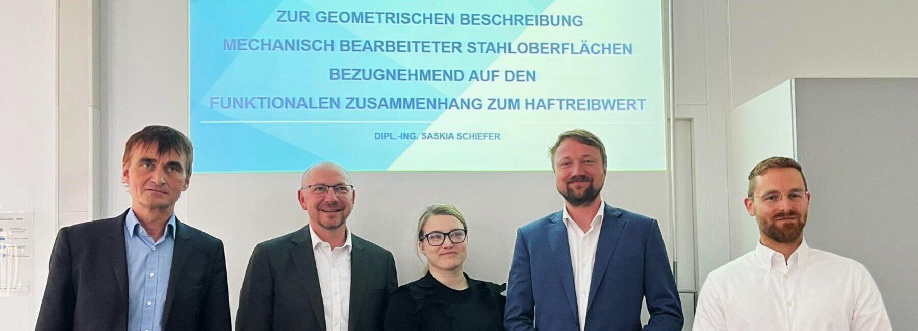 Fünf Personen stehen vor einer Projetionswand