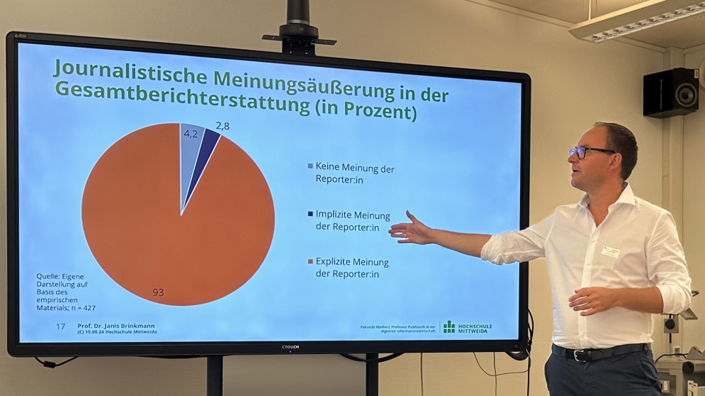 männliche Person steht vor Prsentationswand