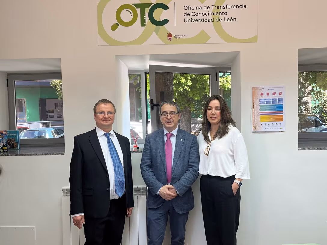 Zwei männliche und eine weibliche Person stehen vor einer Tür, über der das OTC-Logo angebracht ist