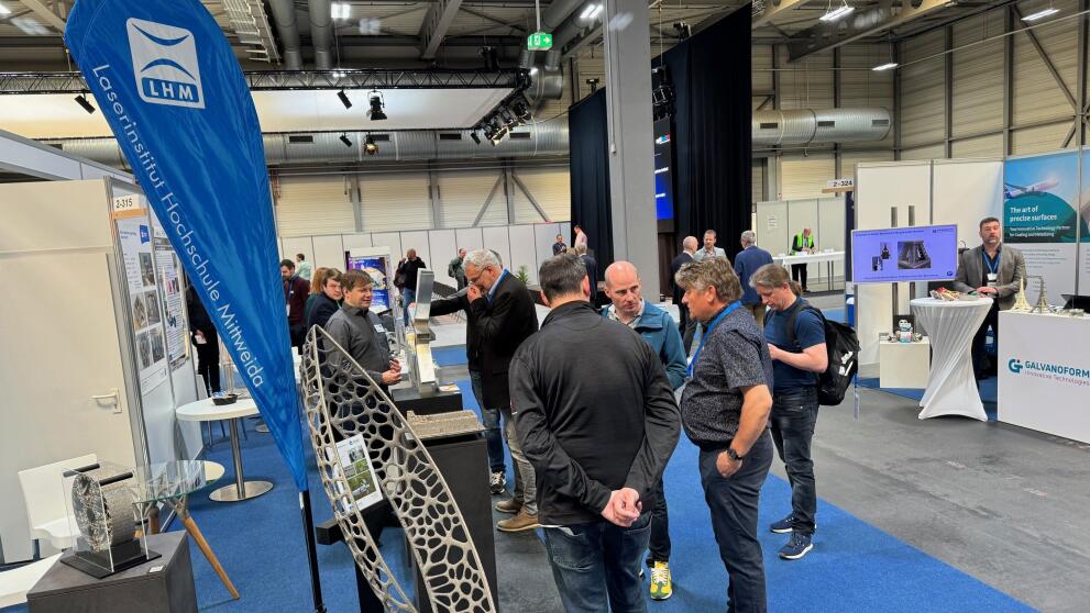 Blick auf einen Messestand mit Besuchenden