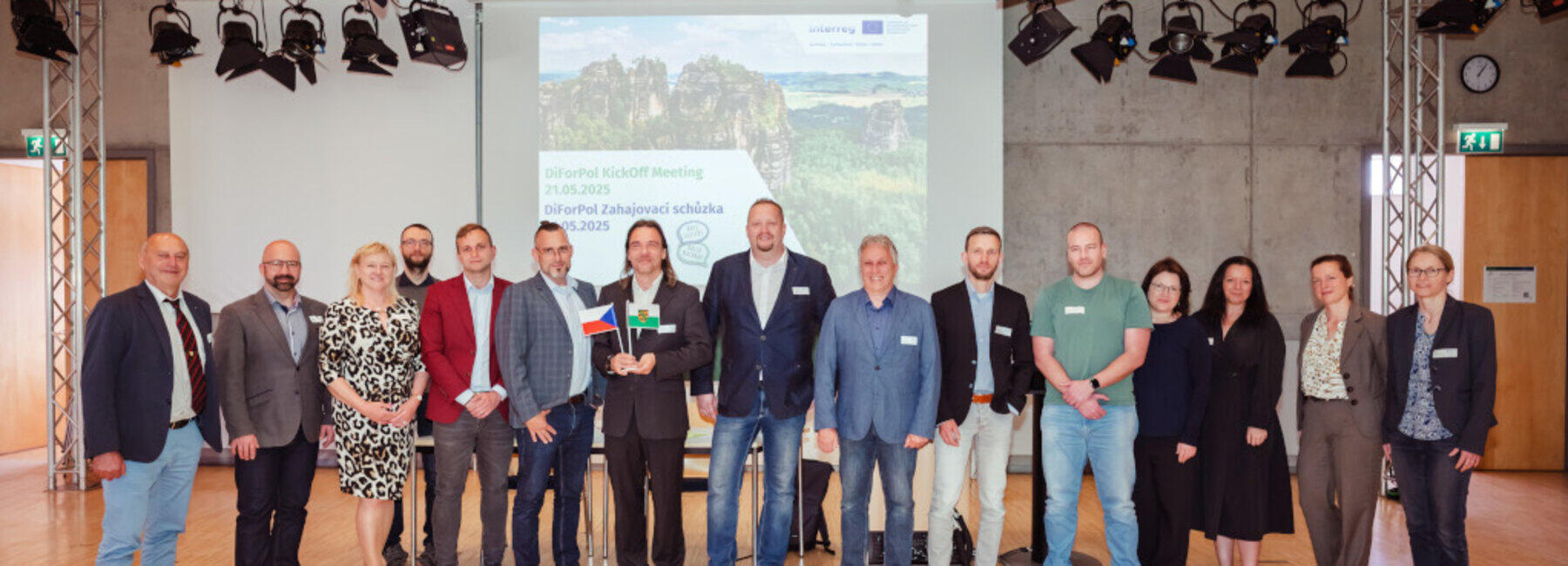 Gruppenbild in einem Studio vor einer Präsentationswand