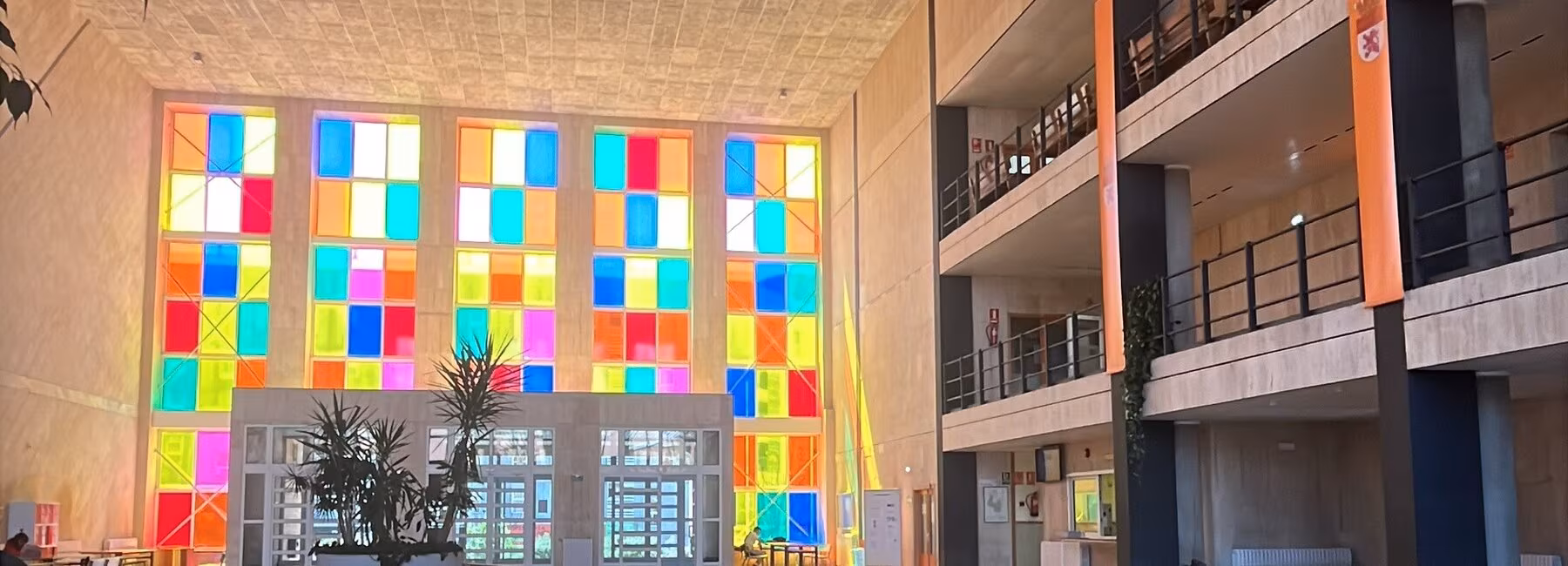 Blick in ein Gebäude mit einer bunten Fensterfront