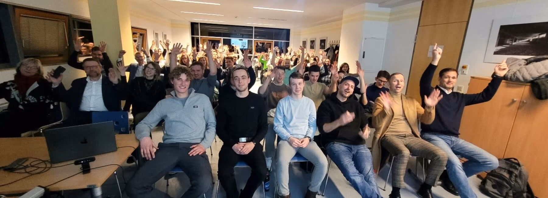 People are sitting on chairs and looking at the camera
