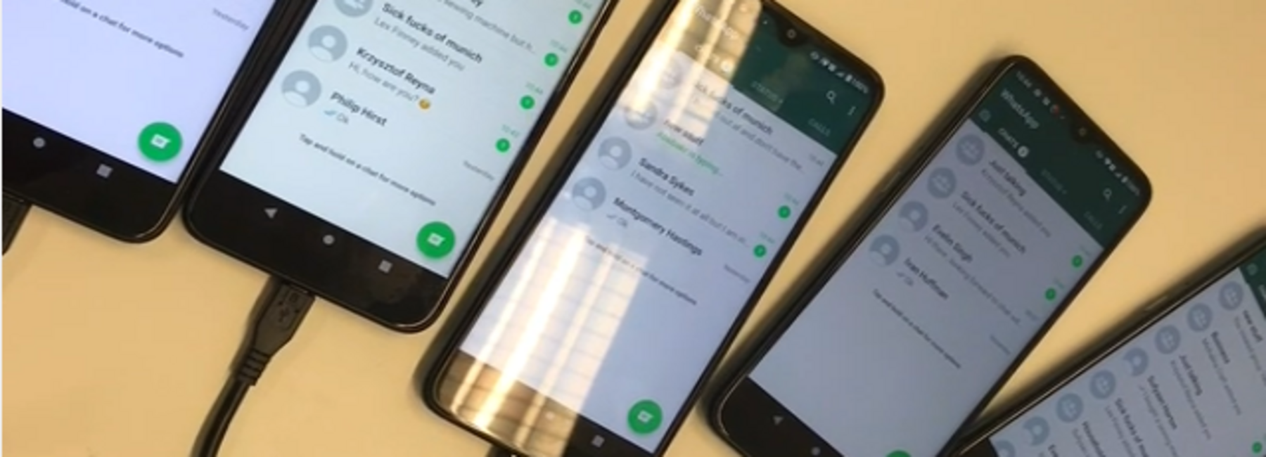 Fünf Smartphones am Ladekabel mit geöffneten Chats