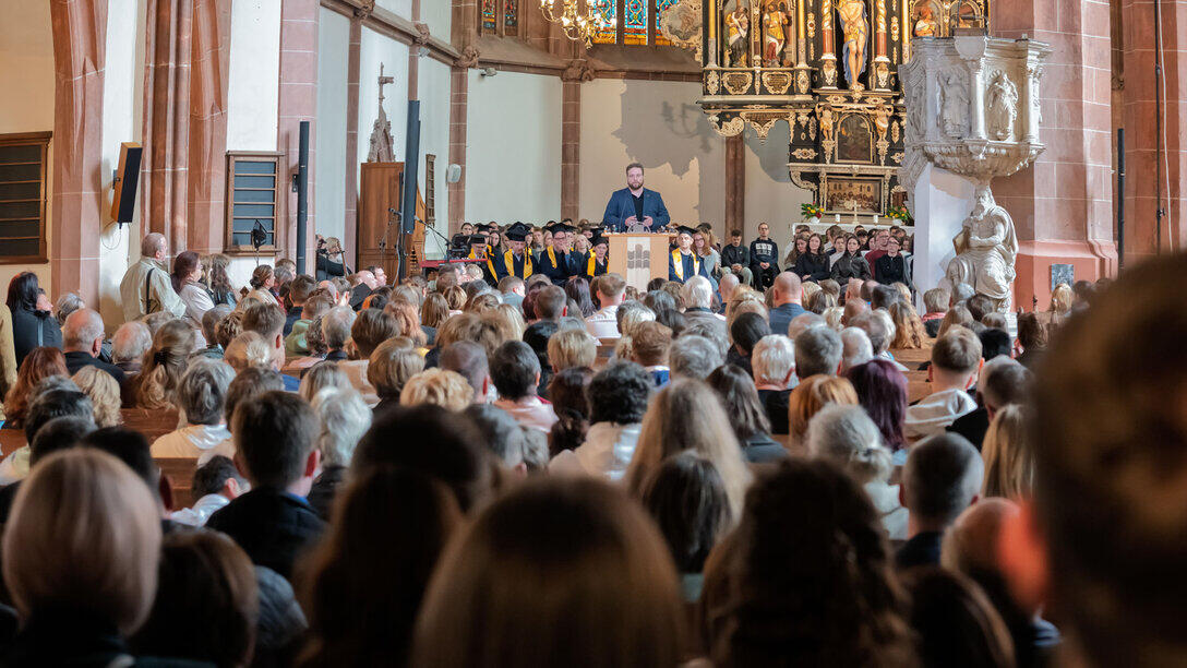 Blick über die Köpfe im vollbesetzten Kirchenschiff in Richtung Altarraum.