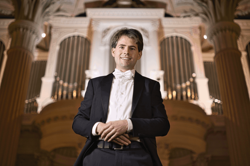 Männliche Person im Frack vor einer Orgel